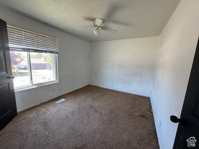 unfurnished room with a ceiling fan and carpet floors