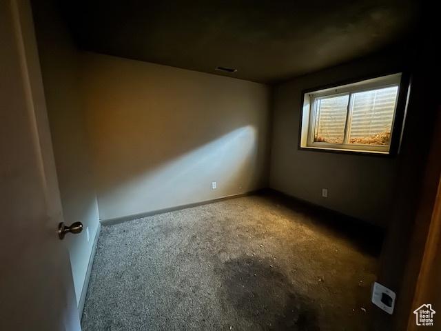 unfurnished room with carpet and baseboards
