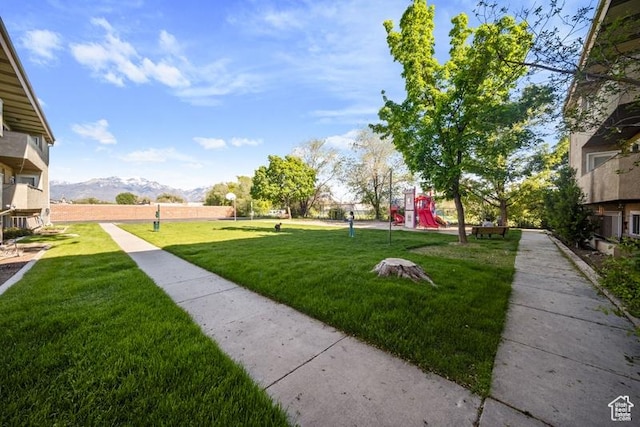 view of community with a yard and a mountain view