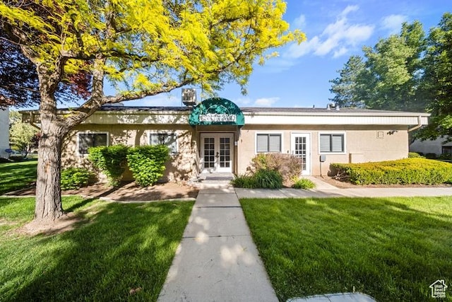 view of front of home with french doors and a front lawn