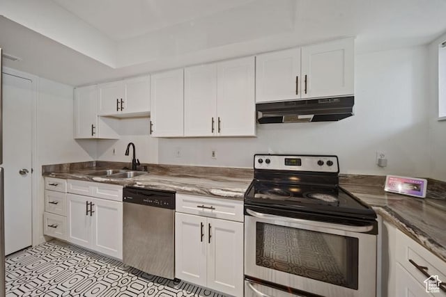 kitchen with appliances with stainless steel finishes, a sink, under cabinet range hood, white cabinets, and stone countertops
