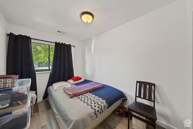 bedroom featuring wood finished floors and baseboards