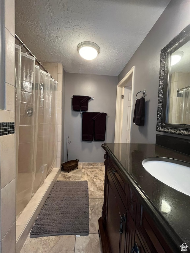 4863 Glasmann Way, Ogden, UT 84403 - bathroom featuring a tile shower, vanity, and a textured ceiling