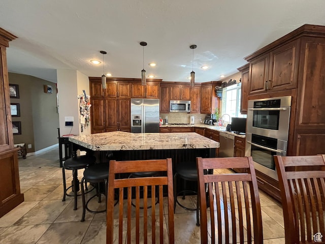 4863 Glasmann Way, Ogden, UT 84403 - kitchen with stainless steel appliances, a kitchen island, a breakfast bar, pendant lighting, and tasteful backsplash