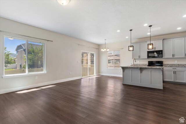 5621 W Stillwell Ln S, Herriman, UT 84096 - kitchen featuring black microwave, stove, a chandelier, baseboards, and recessed lighting