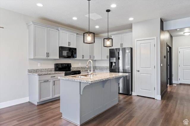 5621 W Stillwell Ln S, Herriman, UT 84096 - kitchen with black appliances, a sink, dark wood finished floors, baseboards, and a center island with sink
