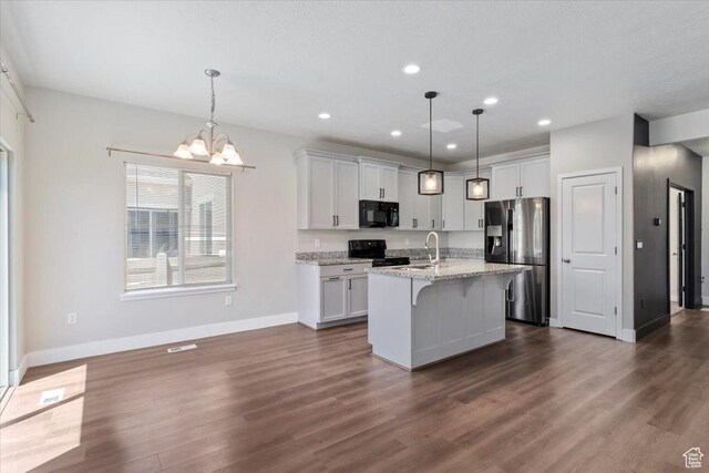 5621 W Stillwell Ln S, Herriman, UT 84096 - kitchen with black appliances, baseboards, dark wood-type flooring, recessed lighting, and a chandelier