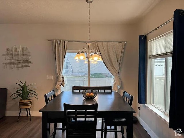 dining room with a chandelier, wood finished floors, and baseboards