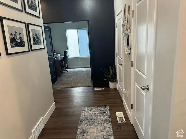 hallway with baseboards, dark wood-type flooring, and a desk