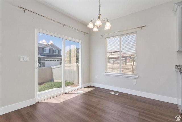 5621 W Stillwell Ln S, Herriman, UT 84096 - unfurnished dining area featuring a chandelier, wood finished floors, and baseboards