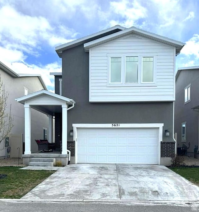 view of front of home with stucco siding, driveway, and a garage
