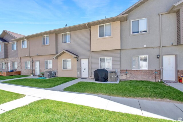 855 W 350 N, Tremonton, UT 84337 - back of house featuring brick siding, a lawn, cooling unit, and stucco siding
