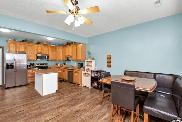 855 W 350 N, Tremonton, UT 84337 - kitchen featuring appliances with stainless steel finishes, ceiling fan, dark wood-style flooring, a center island, and light countertops