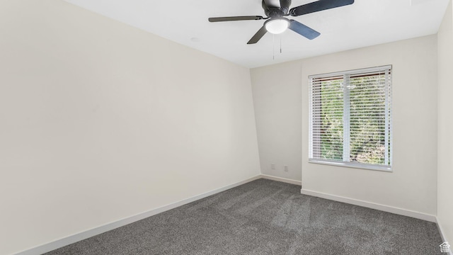 empty room featuring dark carpet, baseboards, and a ceiling fan