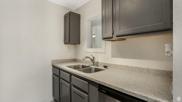 kitchen featuring a sink, gray cabinets, dishwasher, and light stone countertops