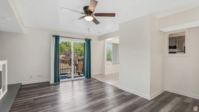 unfurnished living room featuring wood finished floors, a ceiling fan, and baseboards
