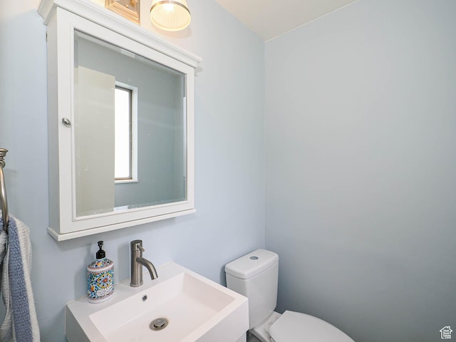 half bathroom featuring a sink and toilet