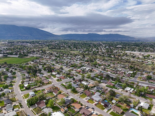 aerial view of property and surrounding area with a mountain backdrop and nearby suburban area