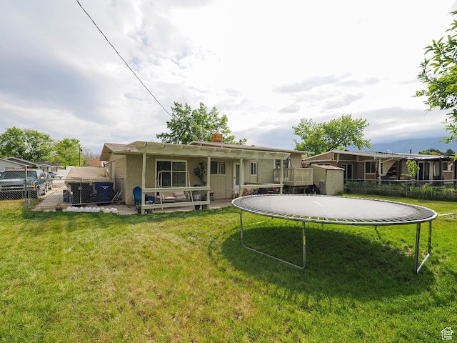 back of house with a trampoline, a chimney, a shed, and an outdoor structure