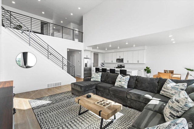 2102 S 2200 W, Woods Cross, UT 84087 - living room featuring light wood-style flooring, recessed lighting, stairs, and a high ceiling