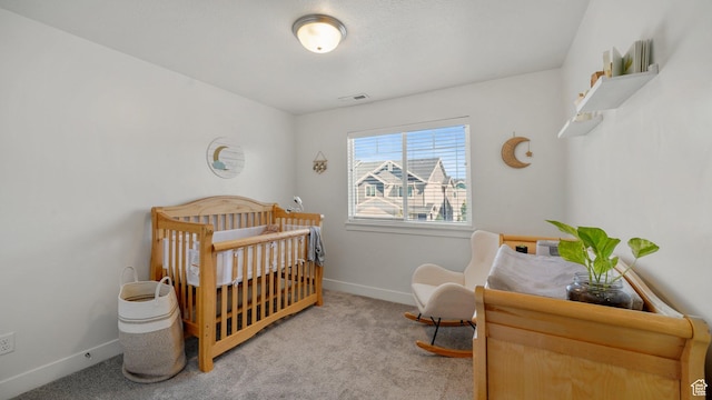 bedroom with carpet flooring, baseboards, and a crib