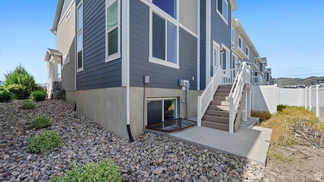 rear view of property with fence, stairs, and a patio