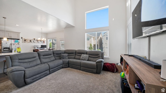 living area with a chandelier and a high ceiling