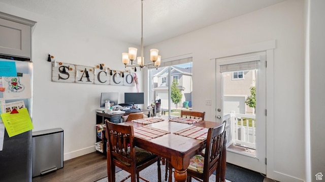 dining space featuring a chandelier, wood finished floors, and baseboards