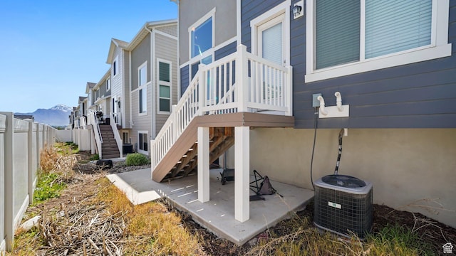 view of patio / terrace featuring cooling unit, stairway, fence, and a mountain view