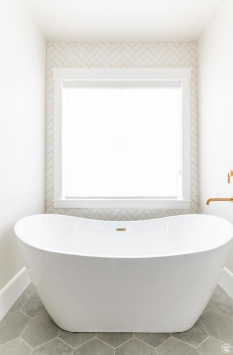 9856 N Sorrel Dr, Eagle Mountain, UT 84005 - bathroom featuring tile patterned floors, a soaking tub, and baseboards