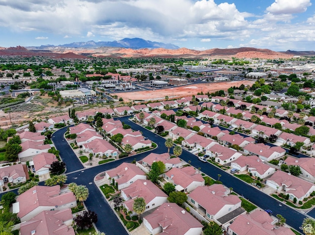 aerial view of property and surrounding area featuring mountains and nearby suburban area