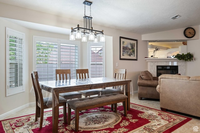 dining area with a fireplace, baseboards, and a textured ceiling