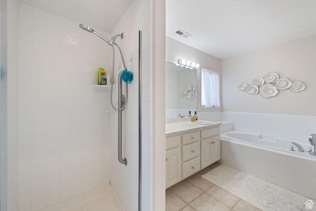 full bathroom featuring tile patterned floors, tiled shower, a bath, and vanity