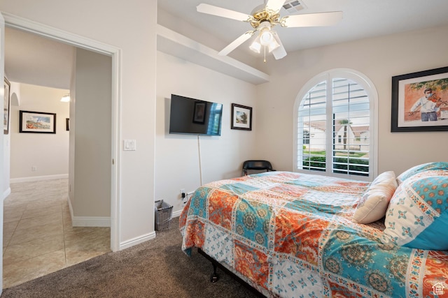 bedroom featuring baseboards, ceiling fan, carpet, and tile patterned floors