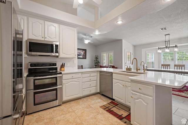 kitchen with stainless steel appliances, ceiling fan, a sink, a peninsula, and recessed lighting