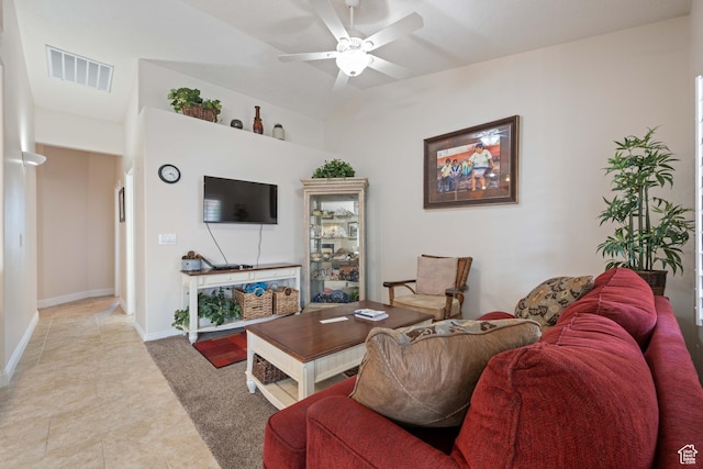living area featuring a ceiling fan, light tile patterned floors, and baseboards