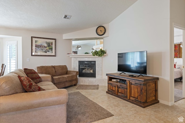 living room featuring a high end fireplace, a textured ceiling, and light tile patterned floors