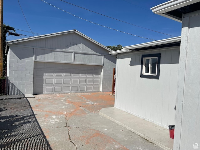 1426 W Carlos Dr S, West Valley City, UT 84119 - view of property exterior with an outdoor structure, a garage, and concrete block siding