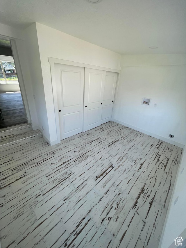 1426 W Carlos Dr S, West Valley City, UT 84119 - unfurnished bedroom with light wood-style floors, baseboards, and a closet
