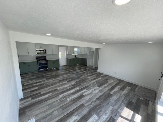 1426 W Carlos Dr S, West Valley City, UT 84119 - unfurnished living room featuring a textured ceiling, dark wood-style floors, a sink, and baseboards
