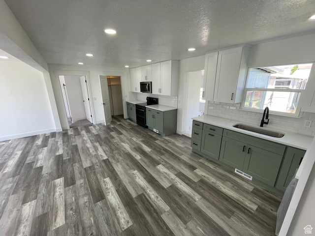 1426 W Carlos Dr S, West Valley City, UT 84119 - kitchen featuring a sink, range with two ovens, stainless steel microwave, recessed lighting, and tasteful backsplash