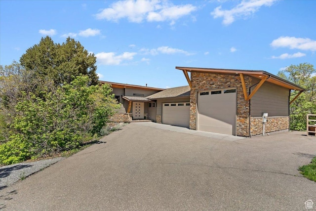1108 N Lakeside Ct, Eden, UT 84310 - view of front of property featuring stone siding, an attached garage, and asphalt driveway
