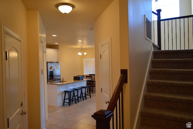 stairs with a chandelier, tile patterned flooring, and recessed lighting