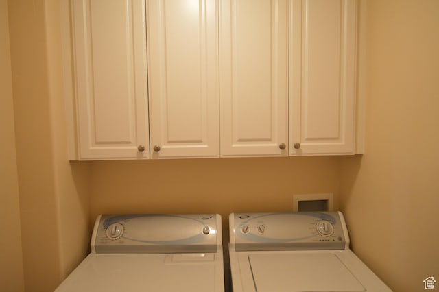 laundry room with separate washer and dryer and cabinet space
