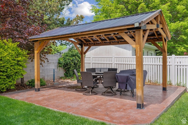 view of patio / terrace with a fenced backyard, outdoor dining area, grilling area, and a gazebo