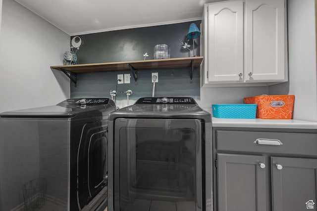 clothes washing area with separate washer and dryer, cabinet space, and ornamental molding