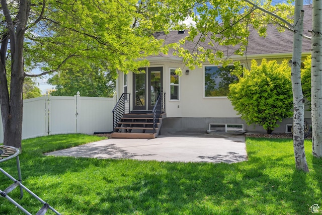 entrance to property featuring a patio area, a gate, and roof with shingles
