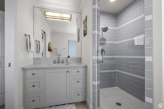 full bathroom featuring ornamental molding, a tile shower, and vanity