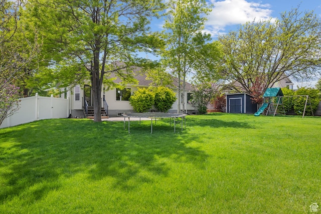 view of yard featuring a playground, a storage shed, entry steps, a trampoline, and an outdoor structure