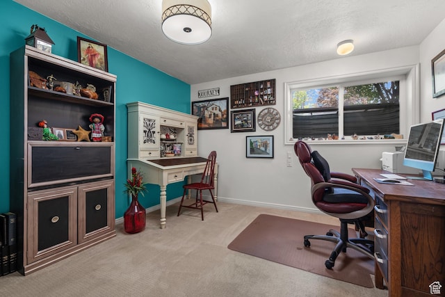 office featuring a textured ceiling, carpet, and baseboards